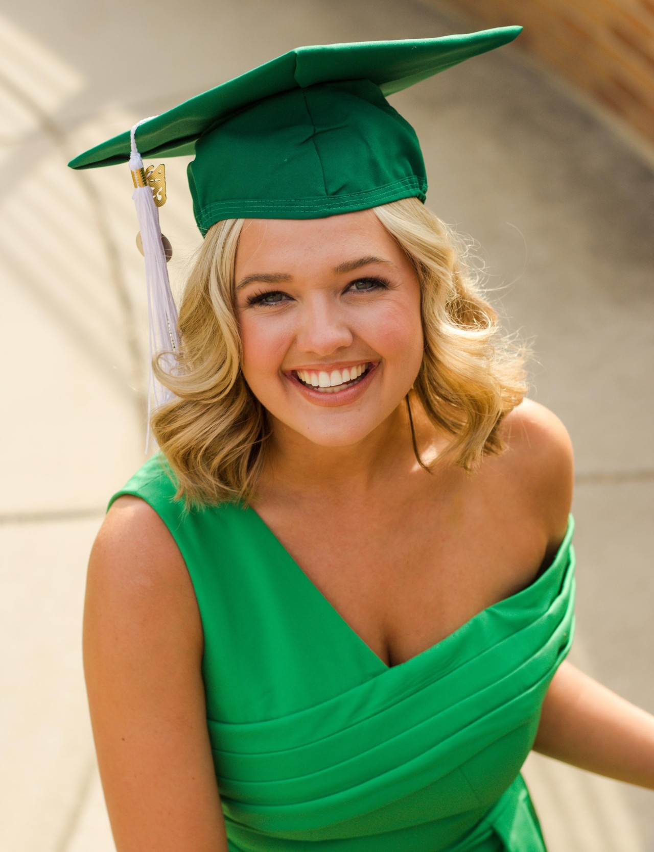 Maya Schuhknecht in green gown and graduation cap.