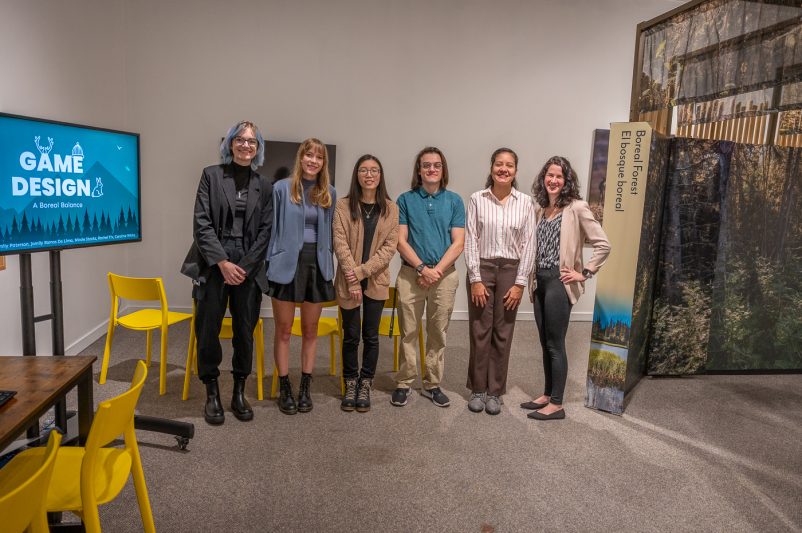 Five MSU students and MSU Museum staffer Caroline White pose in front of the exhibition 