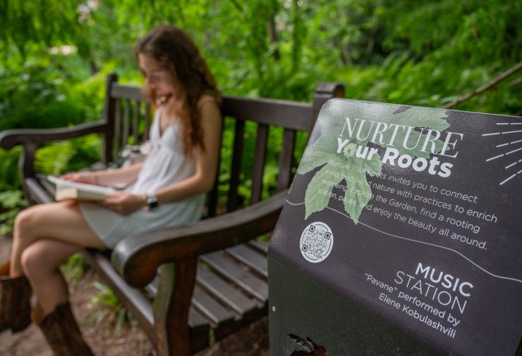 Student sits on bench in Beal Botanical Garden in front of Rooting Station
