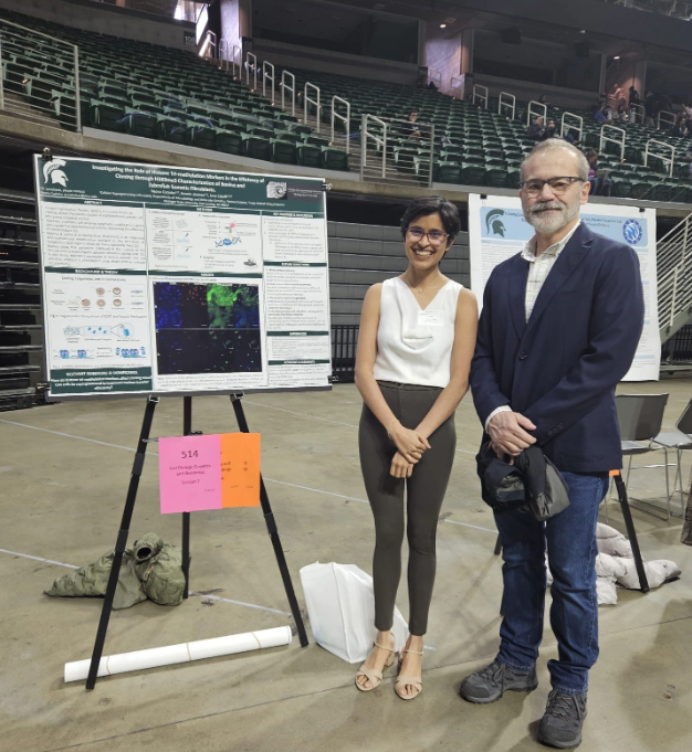 Cutinho and Cibelli at MSU's University Undergraduate Research and Arts Forum in April 2024, standing in front of Veona's research poster.