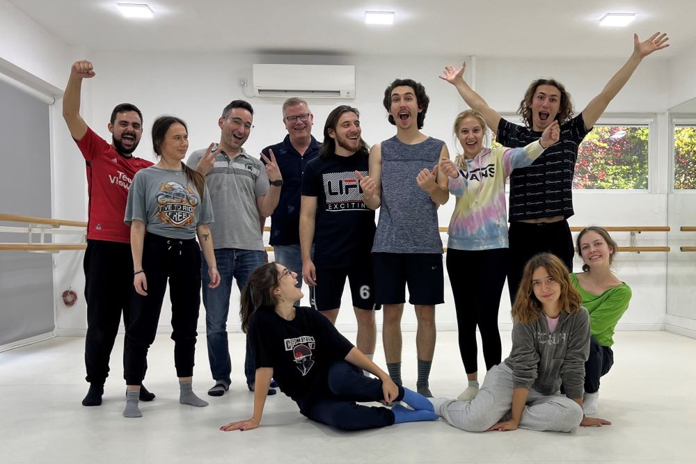 A group of eleven people pose in a studio space.