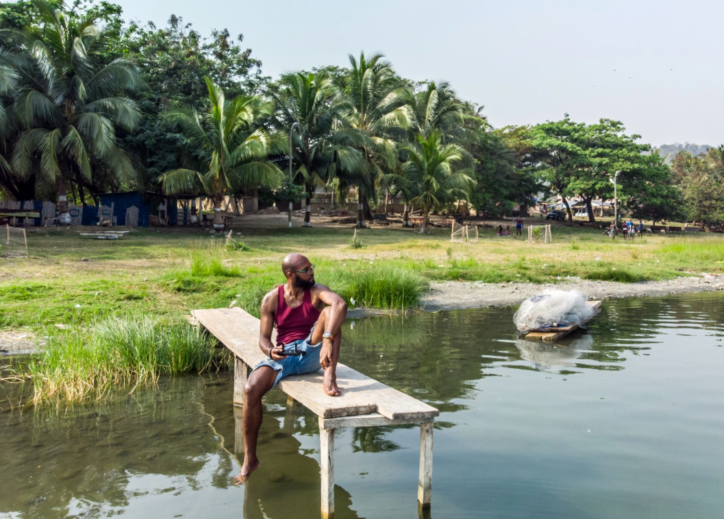 A photo of Vadu sitting at the end of a dock on a lake.