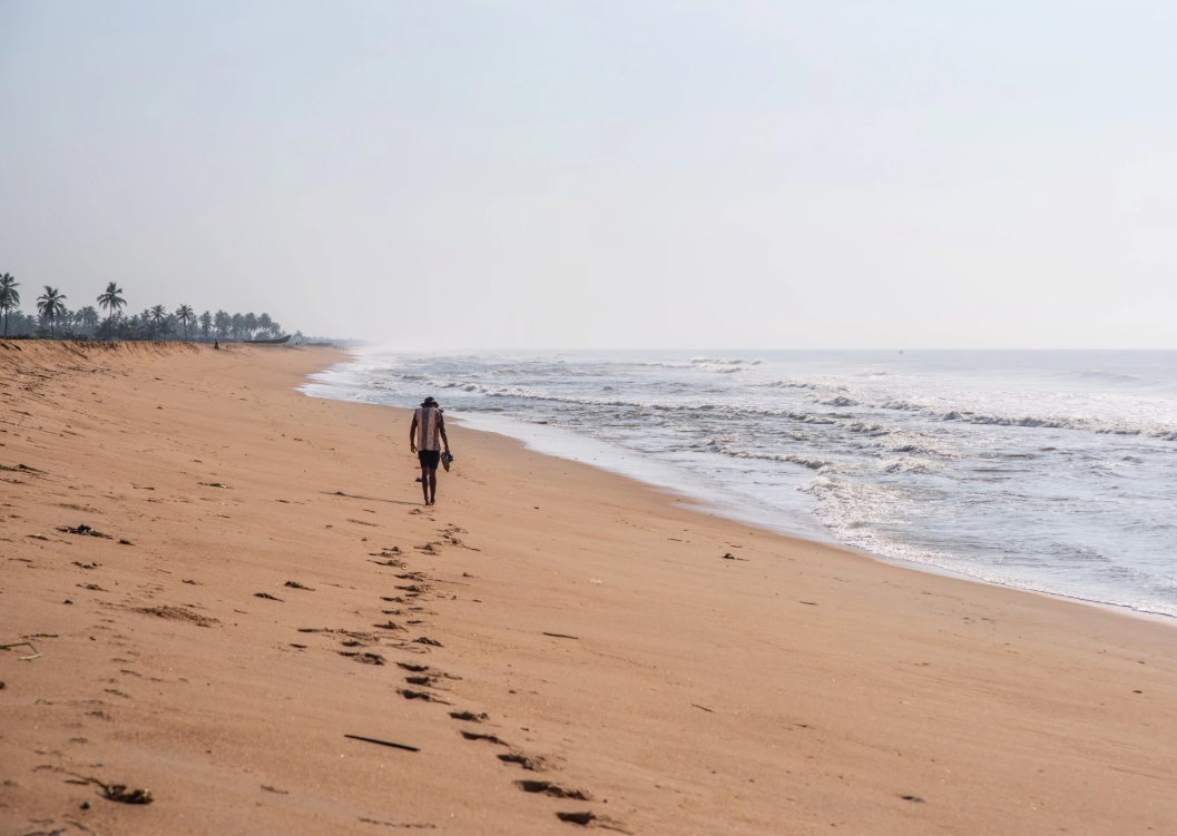 Vadu Rodrigues walking on a beach in Ouidah, Benin