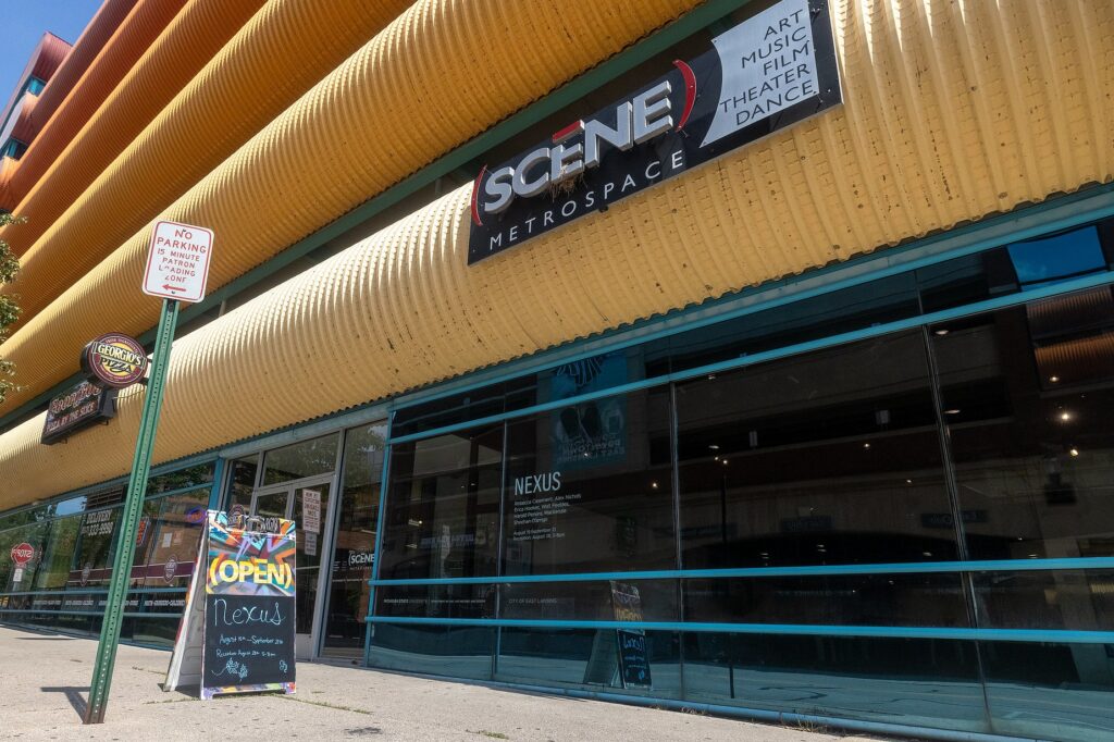 Exterior of the (SCENE) Metrospace gallery in East Lansing. A sidewalk sign reads 