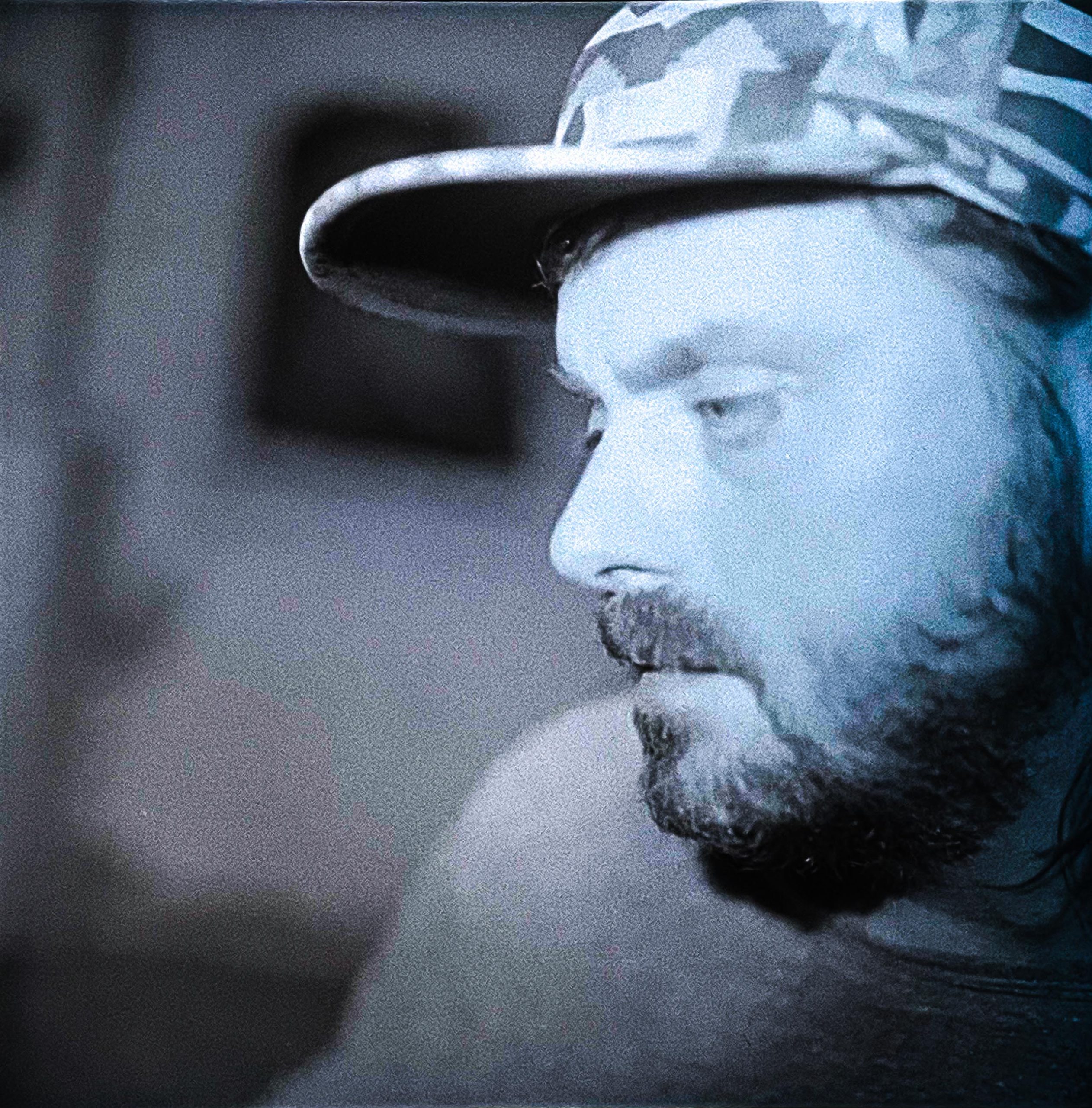 Pixelated blue image of man with beard and baseball hat