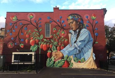 Mural of Indigenous woman picking tomatoes
