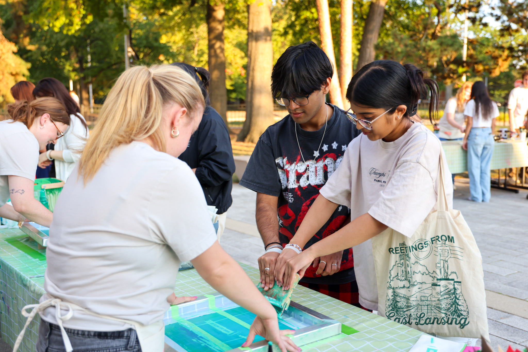 Two students screenprint their own bag outside the MSU Broad Art Museum
