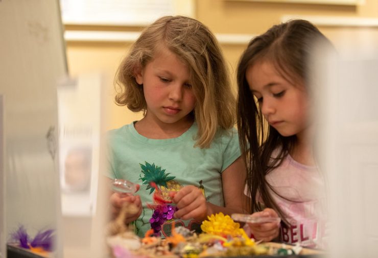Two young girls create with craft materials