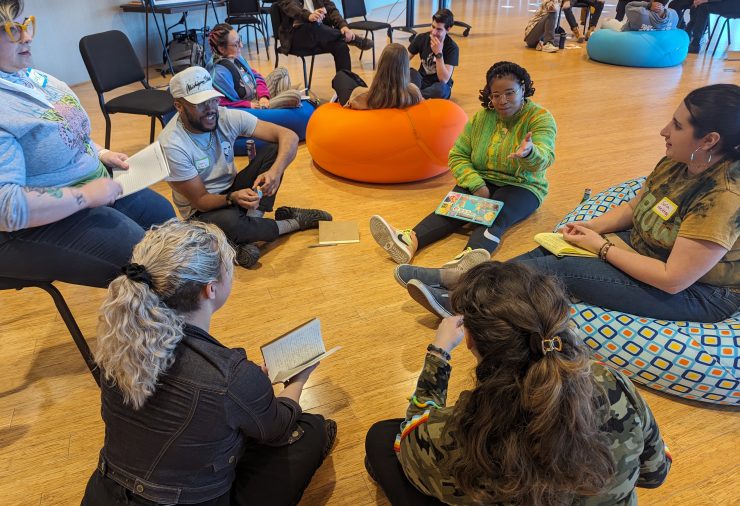 Teachers sit in a circle at Wharton Center to share notes