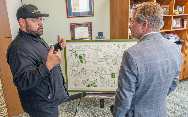 Douglas Jones (left) stands in front of his artwork 