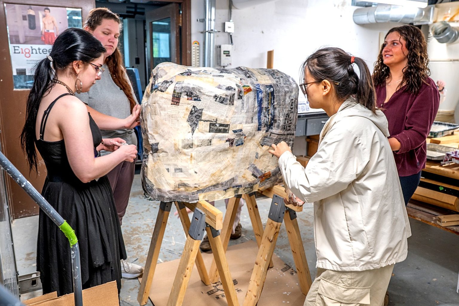 Students apply layers of paper-mache to a large sculptural form in a museum studies to create the paper-mache replica of the MSU Rock.
