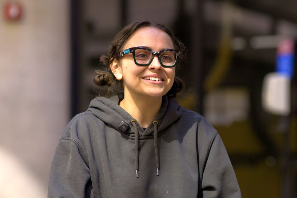 A student wearing glasses and a hooded sweatshirt.