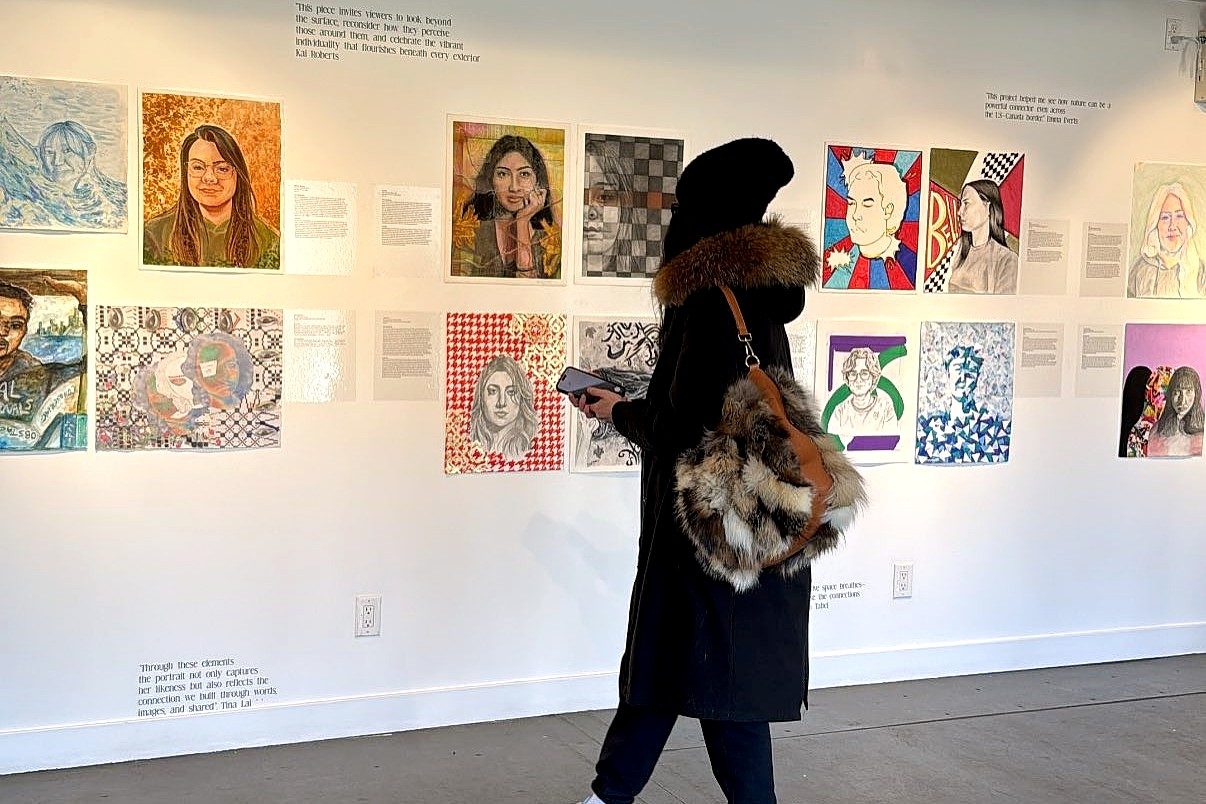 A visitor views a wall of portraits and accompanying text from the 