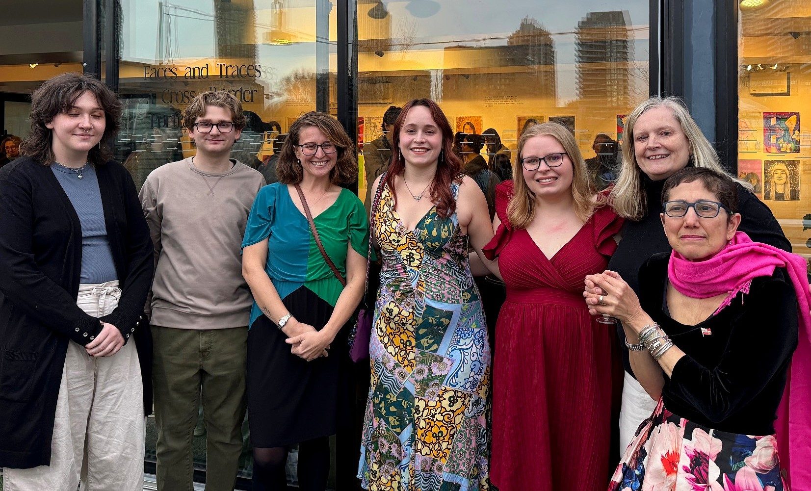 Seven people pose together outside the 