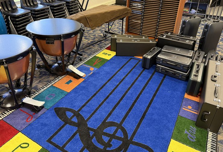 A music classroom with colorful carpet and instruments.
