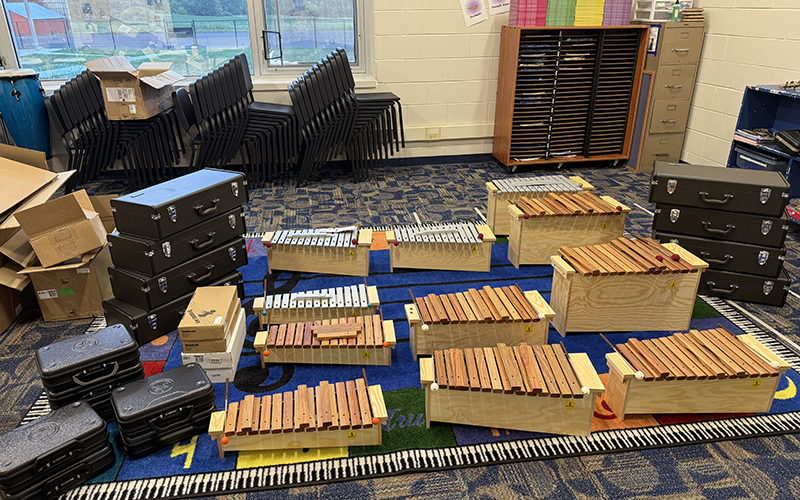 Several musical instruments on the floor of a classroom.