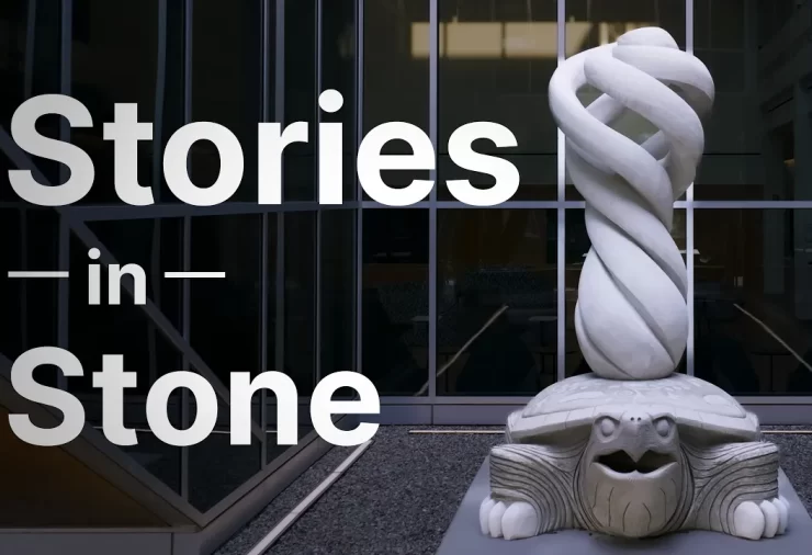 A large sculpture of a turtle in white stone with a swirling cyclone on its back. White text reads 